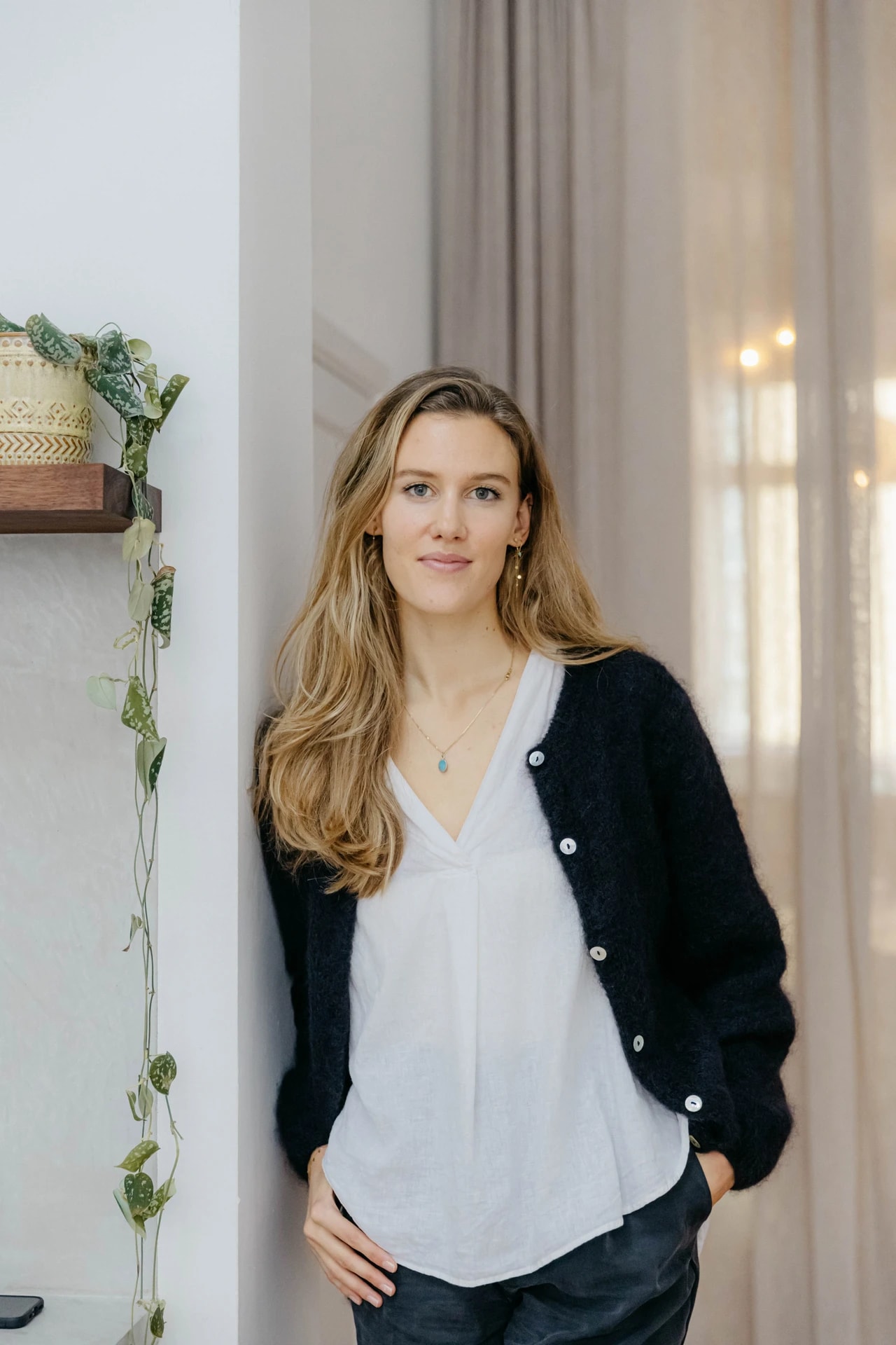 Serafine van Zinder leunt tegen een muur en kijkt naar voor